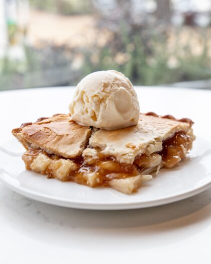 Apple pie with a scoop of vanilla ice cream on top.